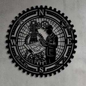 Op de afbeelding: Een cirkelvormig zwart wandkunstwerk met een tandwielvormige rand en een kompasontwerp. Het midden toont het silhouet van een persoon met een helm die een blauwdruk vasthoudt naast een landmeetkundig instrument, met N, Z, O en W markeringen.