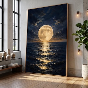 May include: A large vertical framed wall art piece depicting a luminous full moon hanging low over a dark, rippling ocean at night. The golden moonlight creates a bright, shimmering reflection on the surface of the deep blue sea water.
