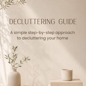 Può includere: Una guida al decluttering digitale con il testo DECLUTTERING GUIDE e A simple step-by-step approach to decluttering your home. L'immagine mostra un vaso chiaro con una piccola pianta, una ciotola piccola e una tazza appoggiate su due libri.