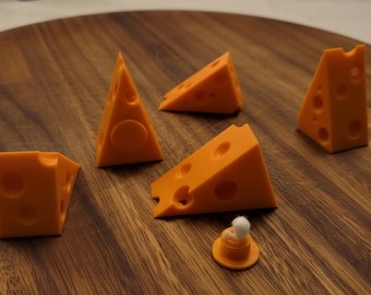 May include: Five orange, triangular cheese-shaped objects with circular holes of varying sizes scattered across the surface, accompanied by a small, round orange base topped with a tiny white sphere.