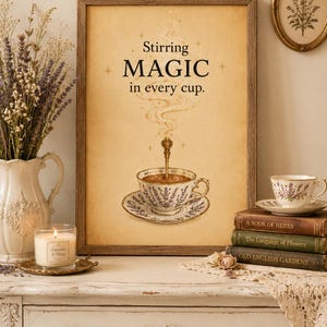 May include: A framed wall art print with a beige background featuring a teacup on a saucer with a spoon, surrounded by steam and small stars. The text reads Stirring MAGIC in every cup. The design includes lavender floral patterns on the teacup.