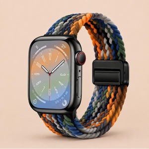 May include: A black smartwatch with a rectangular screen displaying a colourful gradient clock face. The watch features a braided nylon band in a multi-coloured pattern of orange, blue, green, and grey, secured with a black metal adjustable clasp.
