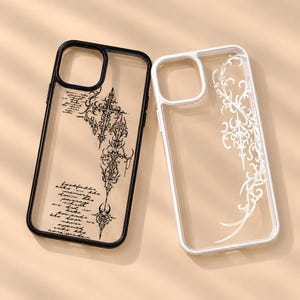 Op de afbeelding: Twee telefoonhoesjes, één met een zwart frame en één met een wit frame. Het zwarte hoesje heeft een complex kruisontwerp en cursieve tekst. Het witte hoesje heeft een wit, krullend filigraanpatroon aan de rechterkant van de behuizing.