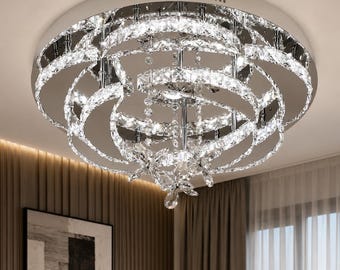 Plafoniera moderna in cromo e cristallo, con anelli LED scultorei e dettagli a forma di farfalla.