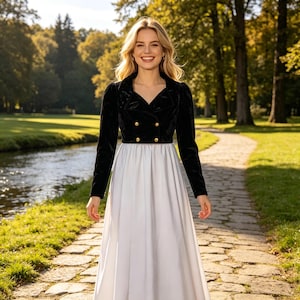 May include: A floor-length dress featuring a black velvet long-sleeve bodice with a notched lapel collar and four gold-toned buttons in a double-breasted arrangement, paired with a solid white, full-length skirt that falls from the waistline.