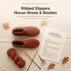 Peut inclure: Une paire de chaussons en tricot côtelé couleur rouille, une pelote de laine assortie, deux aiguilles à tricoter et un tutoriel imprimé intitulé Ribbed Slippers House Shoes & Booties. Le texte indique un modèle de tricot facile pour adultes.