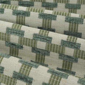 May include: A woven fabric featuring a geometric pattern of raised, textured dark sage green rectangular blocks arranged in a grid, set against a light beige background with thin, intersecting olive green horizontal and vertical lines.
