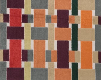 May include: A woven fabric pattern featuring a grid of rectangular blocks in shades of red, orange, dark purple, grey, beige, and dark green. The design consists of vertical and horizontal strips that overlap to create a textured appearance.