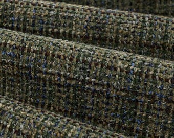 May include: A thick, textured fabric featuring a woven pattern in shades of olive green, dark brown, and navy blue. The material has a multi-dimensional, nubby surface with a dense, interlaced construction that creates a subtle grid-like appearance.