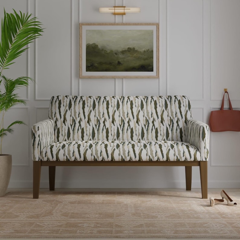 Puede incluir: Un sof&aacute; de dos plazas con un patr&oacute;n abstracto de pinceladas verticales en blanco, verde oliva y beige. El mueble tiene un respaldo recto, dos apoyabrazos y cuatro patas de madera de color marr&oacute;n oscuro. La tapicer&iacute;a cubre el asiento y el respaldo.