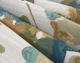 May include: A woven fabric featuring a textured surface with a repeating floral pattern in shades of teal, mustard yellow, and white. The material displays a dense, interlaced weave structure with visible threads creating a multi-colored botanical design.