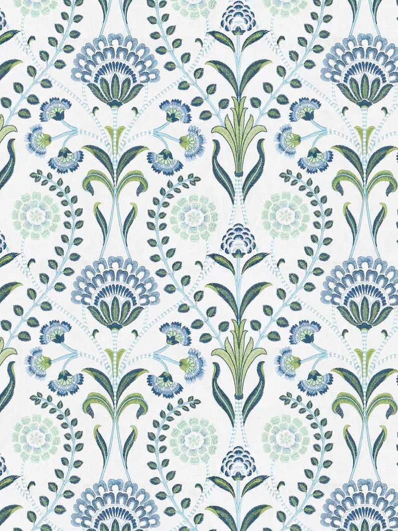 May include: A white fabric featuring a repeating botanical pattern of stylized blue and green flowers, leafy stems, and circular floral motifs arranged in a symmetrical, vertical layout across the entire surface of the material.