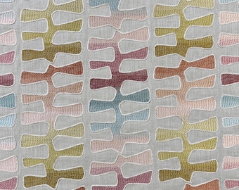 May include: A light gray fabric featuring a repeating vertical pattern of embroidered abstract shapes. The shapes are outlined in white thread and filled with a gradient of colors including olive green, dusty pink, terracotta, and muted blue.
