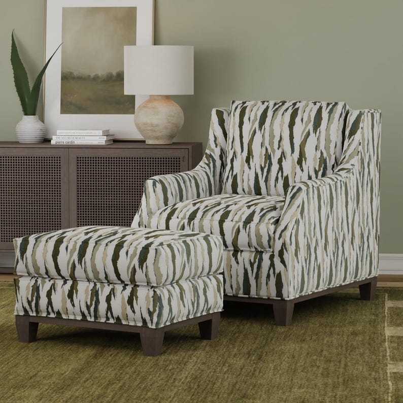 Puede incluir: Un sill&oacute;n tapizado y un reposapi&eacute;s a juego con un patr&oacute;n abstracto vertical en tonos verde oliva, crema y marr&oacute;n oscuro. El conjunto de muebles tiene un respaldo alto, brazos cuadrados y patas de madera de color marr&oacute;n oscuro.