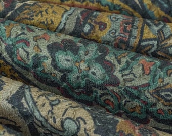 May include: A textile fabric featuring a dense, intricate pattern with a color palette of mustard yellow, muted teal, deep charcoal, and hints of rust red. The material has a soft, textured surface with repeating floral and geometric motifs.