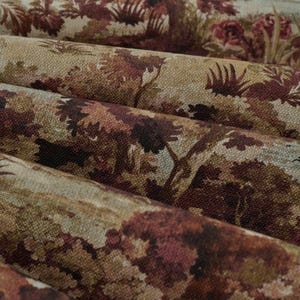 May include: A roll of woven fabric featuring a repeating landscape pattern in shades of deep burgundy, muted brown, and beige. The textile displays a textured surface with detailed depictions of trees and foliage across the entire material.