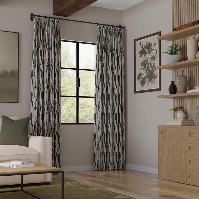 Puede incluir: Cortinas de piso a techo con un patr&oacute;n abstracto vertical en tonos verde oscuro, gris y blanco. Las cortinas cuelgan de una barra de metal negro con anillos, enmarcando una ventana con marco de rejilla negro y cabezales plisados.
