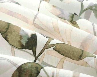 May include: A white fabric featuring a repeating watercolor-style botanical print of olive green leaves and stems. The material is gathered into soft folds, highlighting the texture of the textile and the muted green and beige tones.