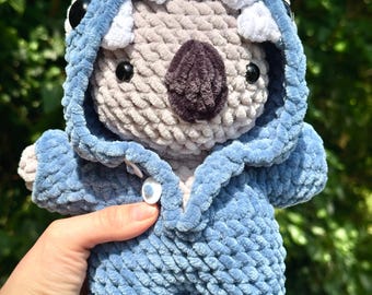 Handmade, crocheted koala or rabbit plush toy in shark pajamas