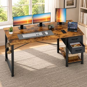 May include: A rectangular computer desk with a rustic brown wood-grain surface and a black metal frame. It features two drawers on the right side, a lower storage shelf, and a side hook for headphones. The desk holds three monitors and a tablet.