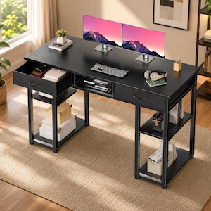 May include: A black computer desk with a textured surface, featuring two drawers, an open center storage shelf, and two side shelving units. The desk holds two monitors displaying a mountain landscape, a keyboard, headphones, and small office items.