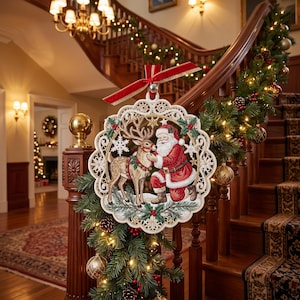 May include: A round, lace-edged Christmas ornament featuring a detailed illustration of Santa Claus kneeling beside a reindeer. The ornament is topped with a red velvet ribbon and hangs against a backdrop of a decorated wooden staircase.