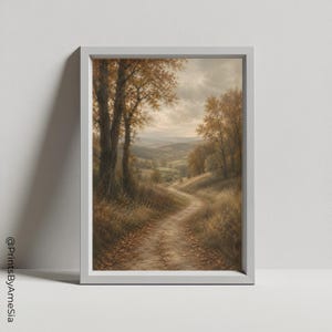 May include: A framed vertical wall art print featuring a landscape painting of a winding dirt path through a golden autumn forest. The scene depicts tall trees with amber foliage, rolling hills in the distance, and a cloudy sky. Text reads @PrintsByAmeSia.