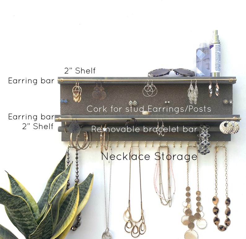 Puede incluir: Un organizador de joyas de pared de madera con dos estantes de 5 cm, dos barras doradas para pendientes, una barra extra&iacute;ble para pulseras y un panel de corcho para pendientes de bot&oacute;n. Incluye ganchos para el almacenamiento de collares.