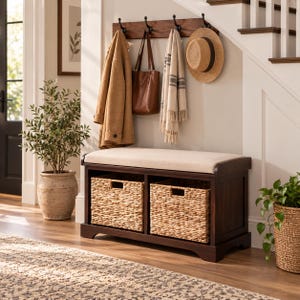 May include: A dark wood entryway storage bench with a beige upholstered seat and two woven seagrass storage baskets. Above the bench, a matching dark wood wall-mounted coat rack features four black metal hooks holding a coat, bag, scarf, and hat.