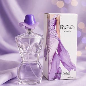 Peut inclure: Un flacon de parfum en verre transparent en forme de torse avec un bouchon violet en forme de chapeau, à côté d'une boîte rectangulaire blanche. La boîte porte le texte Revitalise women, Eau De Parfum, Natural Spray-Vaporisateur, 85ml et 2.88 fl.oz.