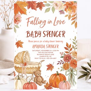 Puede incluir: Una tarjeta de invitación para baby shower con ilustraciones en acuarela de hojas de otoño, flores, calabazas, un cochecito de mimbre y un osito de peluche. El texto dice: Falling in Love, BABY SPENCER, Please join us for a baby shower honoring AMANDA SPENCER, SATURDAY, NOVEMBER 21, 2:00 PM, THE WILLOW HOUSE, 86 MAPLE GROVE LANE, CHARLOTTE, NC, RSVP TO ELLA, 555-294-6817.