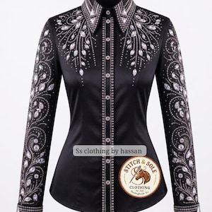 May include: A black long-sleeve button-down shirt featuring intricate clear crystal embellishments arranged in floral patterns across the shoulders, collar, and sleeves. The front placket is lined with small silver studs and clear crystals.