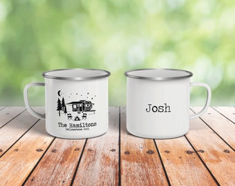 May include: Two white enamel camping mugs with silver rims. One mug has a black and white illustration of a camper, trees, a campfire, and the text "The Hamiltons Yellowstone 2021". The other mug has the name "Josh" printed in black.