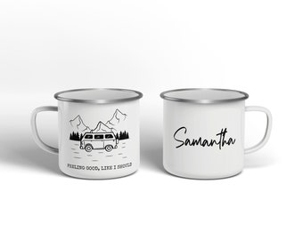 May include: Two white enamel mugs with silver rims. One mug features a black and white illustration of a van driving through a mountain landscape with the text "Feeling good, like I should". The other mug has the name "Samantha" written in black cursive.
