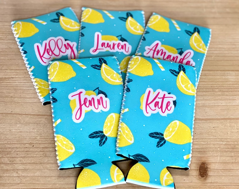 May include: Five personalized drink koozies with a light blue background and a pattern of yellow lemons and white and yellow straws. Each koozie has a different name in pink script: Kelly, Lauren, Amanda, Jenn, and Kate.