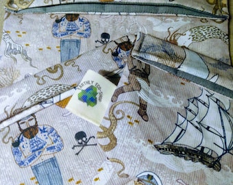 May include: Set of three reusable sandwich bags with a nautical theme. The bags are made of a beige fabric with a repeating pattern of sailors, ships, and sea creatures. The bags are labeled "Earthly Eco-Shop".