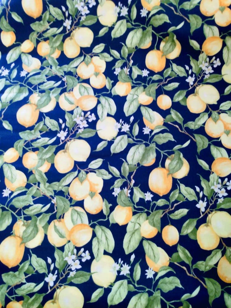 May include: A navy blue fabric with a repeating pattern of yellow lemons and green leaves. The lemons are clustered together on branches with white blossoms.