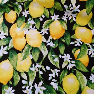 May include: A black background with a repeating pattern of yellow lemons and white blossoms. The lemons are arranged in a random pattern and are surrounded by green leaves.