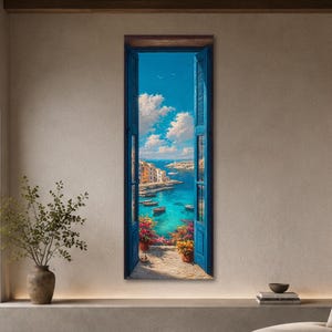 Könnte beinhalten: Ein vertikaler Wandkunstdruck, der ein offenes Fenster mit blauen Fensterläden zeigt, das den Blick auf eine mediterrane Küstenszene freigibt. Zu sehen sind eine türkisfarbene Bucht, kleine Boote, weiße Gebäude und Topfblumen.