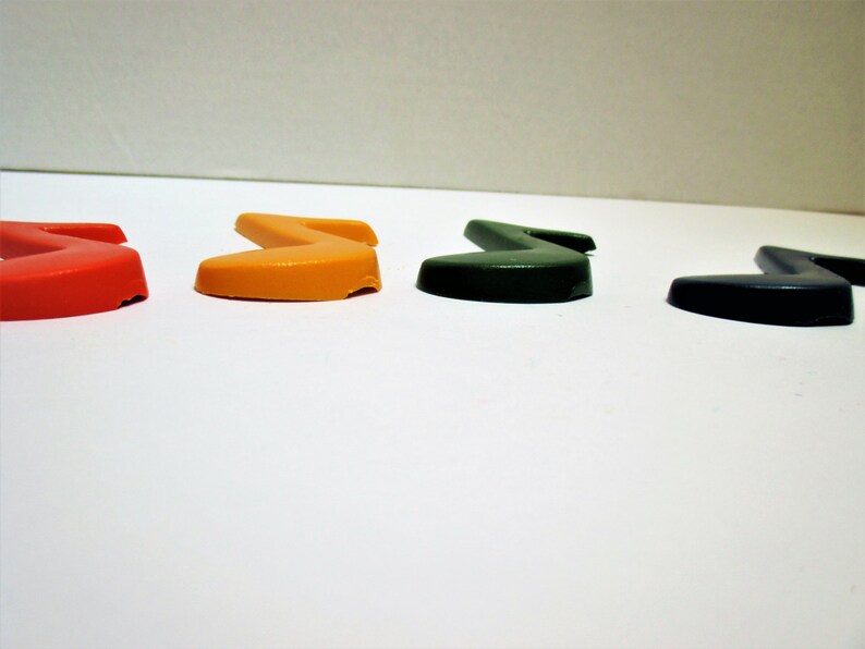 May include: Four plastic musical note shapes in red, orange, green, and black.