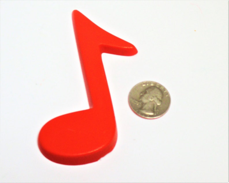May include: A bright red plastic musical note, approximately the size of a UK 20 pence coin.