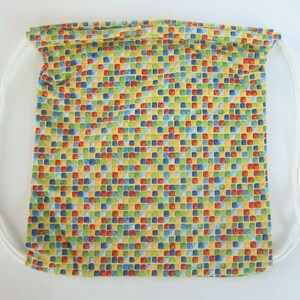 May include: A yellow drawstring bag with a colorful geometric pattern of red, blue, green, and yellow squares.