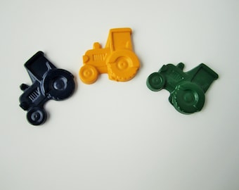 May include: Three toy tractors, one blue, one yellow, and one green. The tractors are made of plastic and have a simple design.