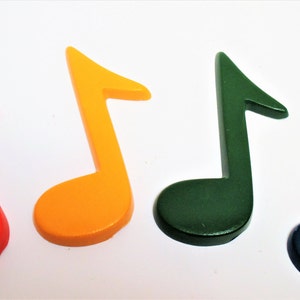 May include: Four colourful music note shapes made of wood. The notes are red, orange, green, and blue.