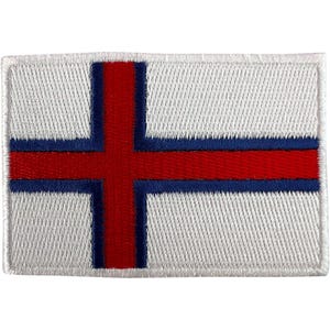 Op de afbeelding: Een rechthoekige geborduurde patch met de vlag van de Faeröer-eilanden. Het ontwerp bestaat uit een witte achtergrond met een rood Scandinavisch kruis met een blauwe omlijning. Het borduurwerk heeft een zichtbaar textuurpatroon over het oppervlak.
