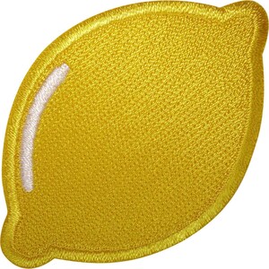 May include: A lemon-shaped embroidered patch featuring vibrant yellow thread throughout the entire surface. A curved white highlight is stitched along the left side of the lemon to create a reflective effect, with a thick yellow border edge.