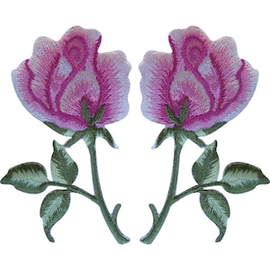 Op de afbeelding: Twee geborduurde rozenpatches met levendige roze en witte bloemblaadjes en gedetailleerde groene stengels en bladeren. Het bloemmotief toont ingewikkelde stikpatronen die een getextureerd uiterlijk geven aan elke individuele rozenbloem.
