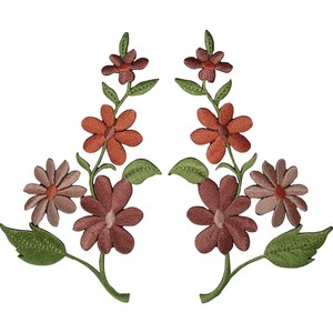 Può includere: Due toppe floreali ricamate simmetriche con steli, foglie verdi e fiori nelle tonalità ruggine, terracotta e malva tenue. Ogni toppa presenta una disposizione verticale di fiori con cuciture dettagliate su uno sfondo a tinta unita.