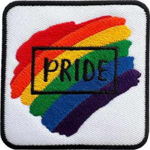 Peut inclure: Un écusson brodé carré avec un fond blanc et une bordure noire. Le centre présente un motif de coup de pinceau diagonal aux couleurs de l'arc-en-ciel avec le mot PRIDE brodé en lettres capitales noires dans un contour rectangulaire noir.
