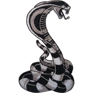 May include: An embroidered patch featuring a coiled cobra snake in a striking black, white, and grey colour scheme. The snake is depicted with its hood flared, mouth open, and fangs exposed, showcasing detailed stitching throughout the design.